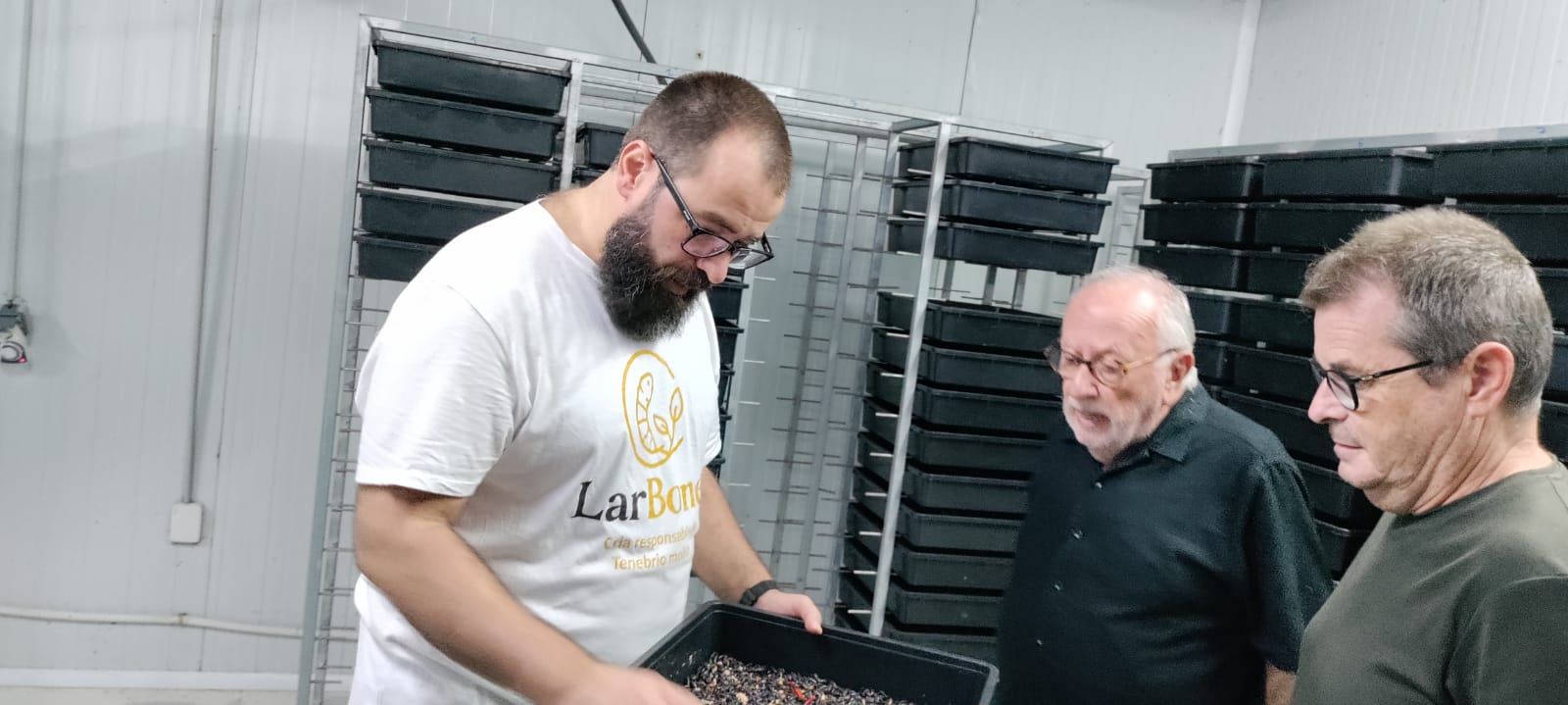 Miquel mostrant una safata de larves de Tenebrio molitor a dos mentors del SECOT a la sala de cria de LarBones